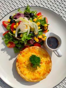 a plate of food with a salad and a omelet at Bale Sampan Boutique Bungalows in Gili Trawangan