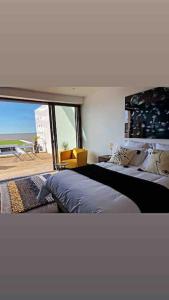 1 Schlafzimmer mit 2 Betten und einem großen Fenster in der Unterkunft Villa Angoulins front de mer in Angoulins-sur-Mer