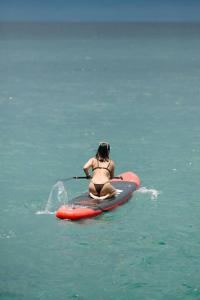 een vrouw in bikini zittend op een paddleboard in het water bij Exclusive Cliff House with Pool and Beach Access in Dumanjug