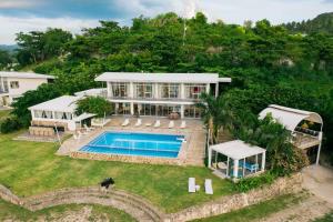 an aerial view of a house with a swimming pool at Exclusive Cliff House with Pool and Beach Access in Dumanjug