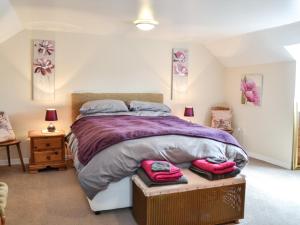 鄧弗里斯的住宿－Keepers Cottage，一间卧室配有一张床,上面有两条毛巾