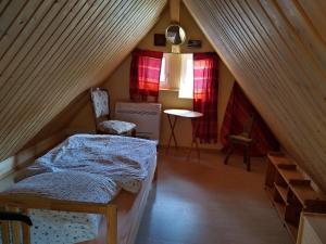 a room with a bed and a table in a attic at Ferienhaus Kimmelsbacher Hof - Sauna & Naturpool in Bundorf