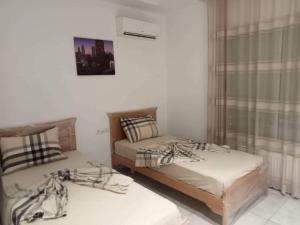 two twin beds in a room with a window at Le lagon de Hammamet in Hammamet