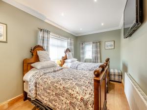 a bedroom with two beds and a flat screen tv at The Old Farmhouse in Ancroft