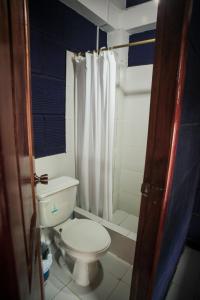 W łazience znajduje się biała toaleta i prysznic. w obiekcie Hostel El Gran Azul Olon w mieście Olon