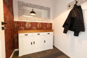baño con armario blanco y espejo en Ferienhaus Hus Oetti en Ostseebad Sellin
