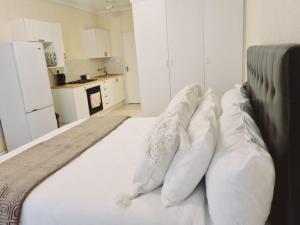a white bed with white pillows on top of it at Hatfield Grosvenor Private Apartments in Pretoria