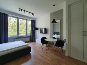 1 dormitorio con 1 cama, mesa y sillas en Chopin Apartments Expo en Varsovia