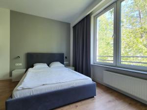 sypialnia z łóżkiem i dużym oknem w obiekcie Chopin Apartments Expo w Warszawie