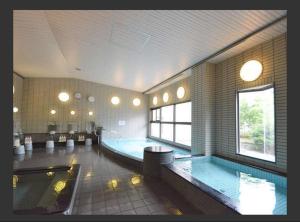 a large swimming pool in a large room with a pool at Isawa no Sato in Shiso