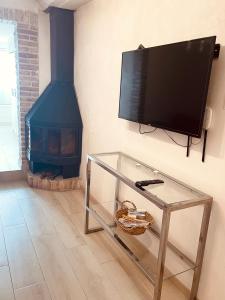 a living room with a tv on the wall with a fireplace at El Nido: Una casita de ensueño in Deltebre