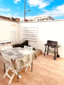 un tavolo e sedie su un patio con griglia di El Nido: Una casita de ensueño a Deltebre
