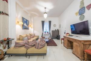 a living room with two couches and a flat screen tv at Athenian Niche in Plaka Villa by Athenian Homes in Athens