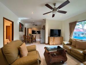 a living room with a couch and a ceiling fan at Resort 2-3BR Huge Pool, BBQ, 300m-Beach, 5 mins to Walking Street in Pattaya South