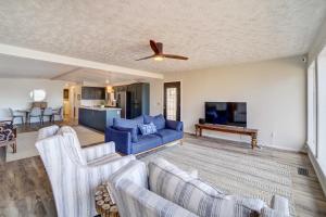 a living room with a blue couch and a tv at Lake Hudson Home with Patio in Locust Grove in Locust Grove