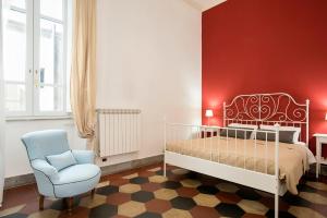 - une chambre avec un lit blanc et une chaise bleue dans l'établissement Casa Coronari Holidays, à Rome