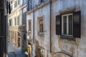 un vieux bâtiment avec des fenêtres sur le côté d'une rue dans l'établissement Casa Coronari Holidays, à Rome