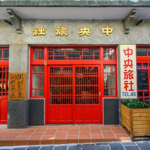 a red door of a building with writing on it at 中央旅社 in Magong