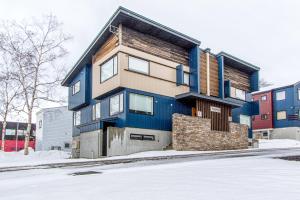 a blue house with snow on the street at Wajima Niseko in Niseko