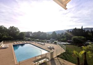 basen z leżakami i widokiem na miasto w obiekcie Appartement 5 en duplex, avec deux chambres - LES SUITES DE ROBINSON - Résidence avec piscine en bord de Siagne, à Mandelieu-La-Napoule w mieście Mandelieu-la-Napoule