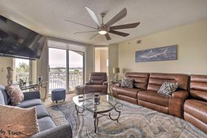a living room with leather furniture and a ceiling fan at Barefoot Resort Condo with Balcony and Pool Views! in Myrtle Beach