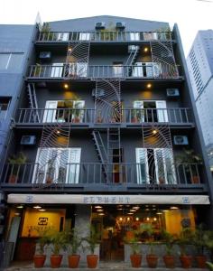 un edificio alto con balcones y macetas. en ELEMENT BOUTIQUE HOTEL en Manila