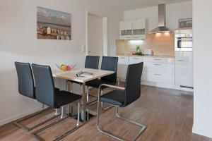 Una cocina con mesa de comedor y sillas. en Exquisit 8, en Norderney 4 fotos más