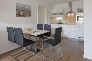 a dining room table and chairs in a kitchen at Exquisit 8 in Norderney