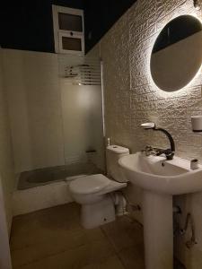 een badkamer met een toilet, een wastafel en een spiegel bij Especially villa with private entrance, garden and parking in Caïro
