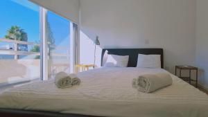 een slaapkamer met een groot bed en handdoeken bij STAY Vivid City Apartment in Limassol