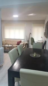 uma sala de jantar com uma mesa e cadeiras e um sofá em The Flats em Ávila