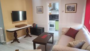 a living room with a couch and a table with a tv at The Flats in Ávila