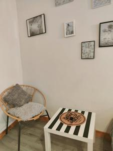 ein Wohnzimmer mit einem Stuhl und einem Tisch in der Unterkunft Le Ty Rose in Dinan