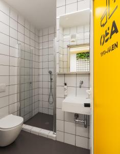 a bathroom with a shower and a toilet and a sink at Wom Allenby Pod Hotel - a member of Brown Hotels in Tel Aviv
