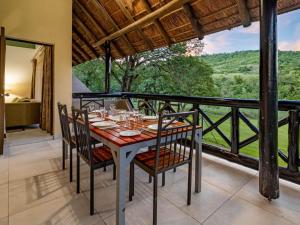 a dining room with a table and chairs on a balcony at Leisure Time Rentals - Sanbonani Resort & Spa in Hazyview