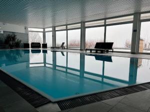 a swimming pool with blue water in a building at Ferienwohnungen Bayerischer Wald mit Pool in Freyung