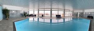a large swimming pool in a large building at Familienfreundliche Ferienwohnung Bayerischer Wald mit Pool in Freyung +20 photos