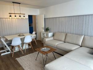 a living room with a white couch and a table at Ferienwohnungen Bayerischer Wald mit Pool in Freyung