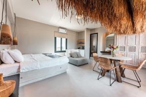 a bedroom with a bed and a table and chairs at IfestAu.4 Suites in Fira