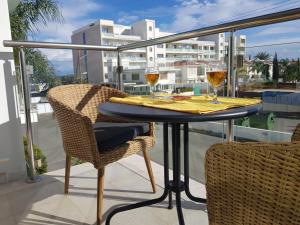 einen Tisch mit zwei Gläsern Wein auf dem Balkon in der Unterkunft Coralli Spa Resort Protaras Stylish 1 Bedroom apartment in Protaras