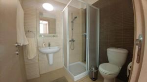 ein Bad mit einer Dusche, einem WC und einem Waschbecken in der Unterkunft Coralli Spa Resort Protaras Stylish 1 Bedroom apartment in Protaras