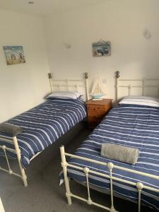 two beds sitting next to each other in a bedroom at An Entire Fabulous Holiday Home - It’s All Yours! in Saint Columb Major