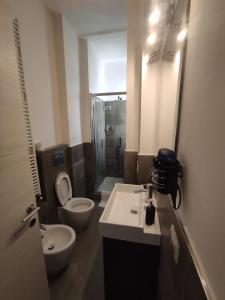 ein Badezimmer mit zwei Waschbecken, einem WC und einem Spiegel in der Unterkunft Il Portico Affittacamere Bologna in Bologna