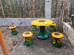 a table with yellow and green mushrooms next to a fence at ANNI'S BEACH HOUSE in Lucena