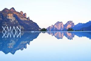 a reflection of mountains in a lake with the word xxx at XMAN Valley Sunrise Resort in Zhangjiajie