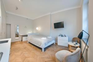 1 dormitorio con 1 cama y TV en la pared en Apartamenty Sun & Snow Old Town Gdańsk, en Gdansk