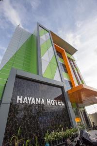 Taruna的住宿－HAYANA HOTEL，前面有宫内酒店标志的建筑