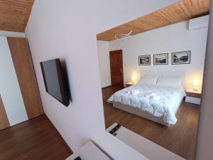 een slaapkamer met een bed en een flatscreen-tv bij E&E Home Sweet Home in Tirana