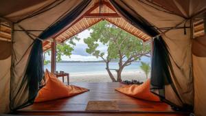 an inside of a tent with a view of the beach at Lihaga Island & Beach Club in Serai