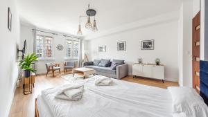 a white bedroom with a bed and a couch at Apartamenty Sun & Snow Old Town Gdańsk in Gdańsk